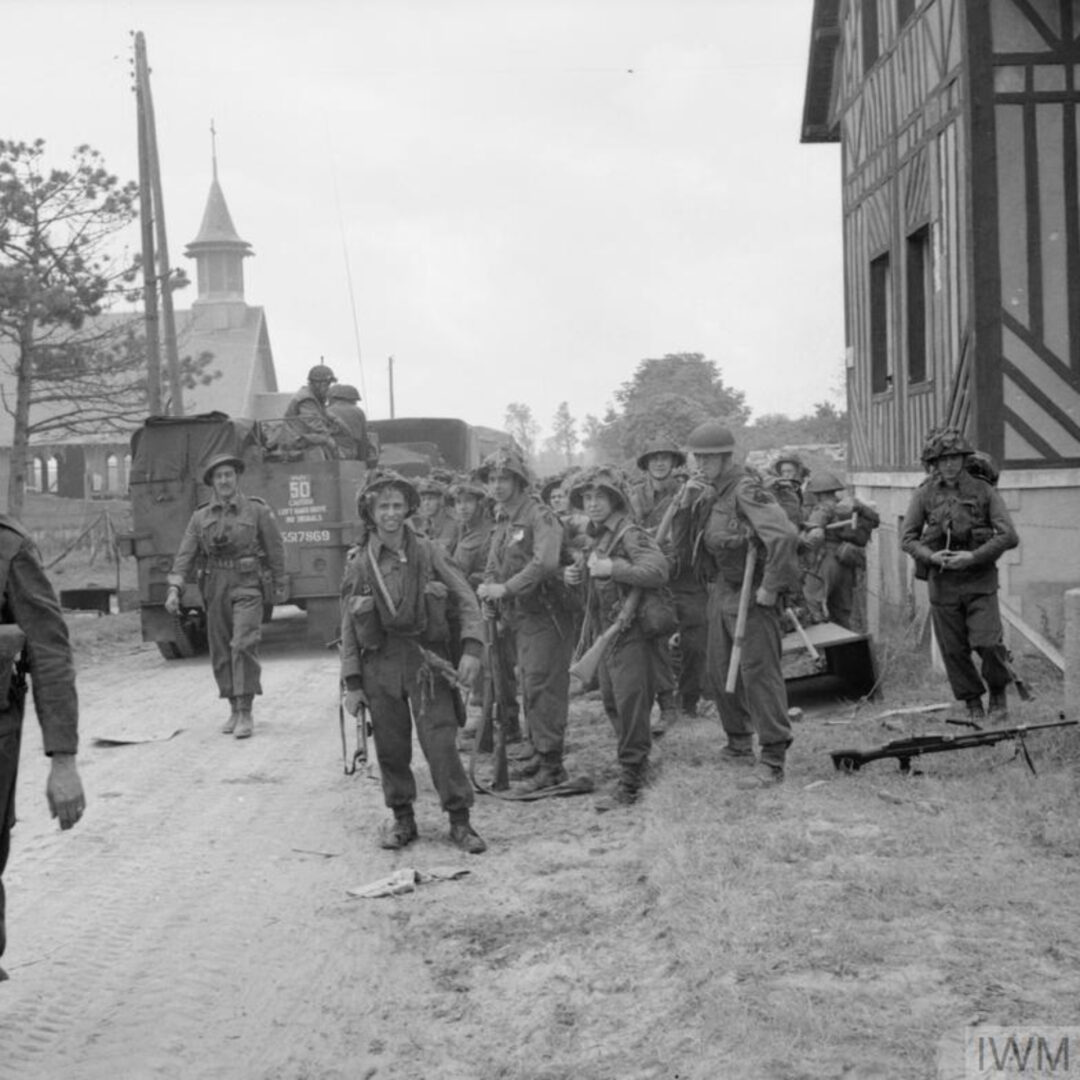 Soldiers of 3rd Infantry Division including Dubliner Charles Feeney (with Bren Gun) of 2nd Battalion, Royal Ulster Rifles pause at La Bréche d'Hermanville as they move inland during the Normandy landings. The half-track is from No. 246 Field Company, Royal Engineers.