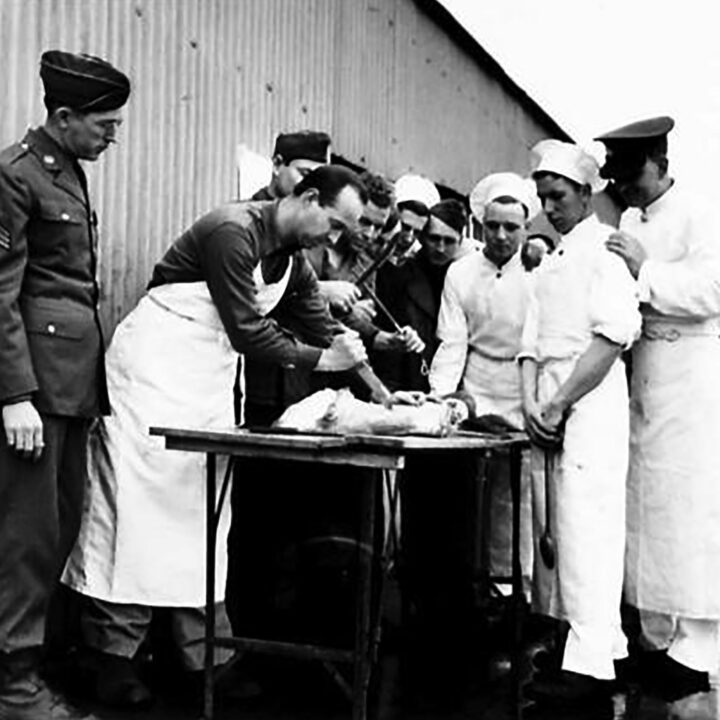 An American Army butcher shows British cooks how they cut joints of meat in Carrickfergus, Co. Antrim on 2nd February 1942