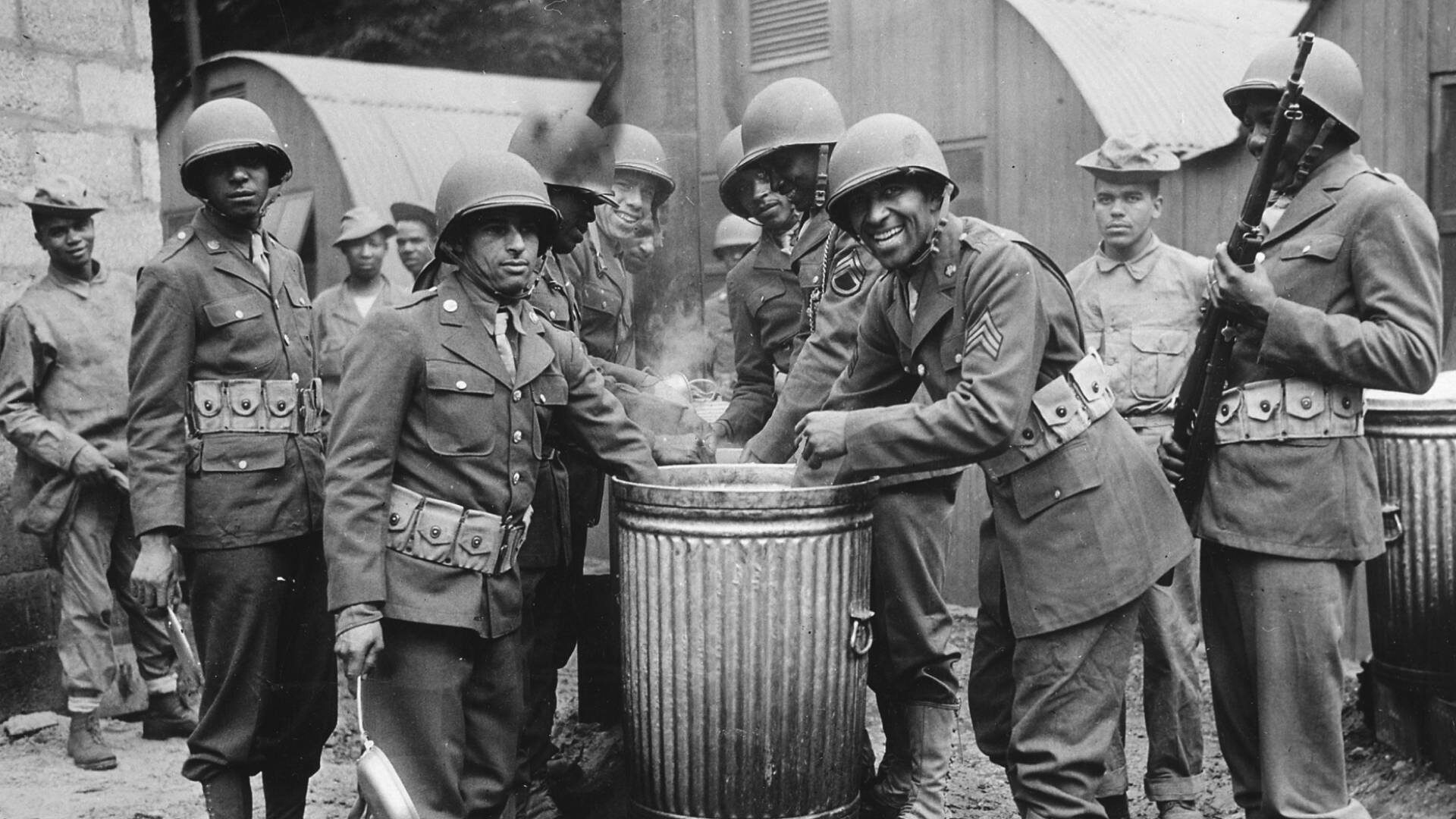 A group of black service personnel serving in the U.S. Army draw rations at a cookhouse in Northern Ireland in 1942