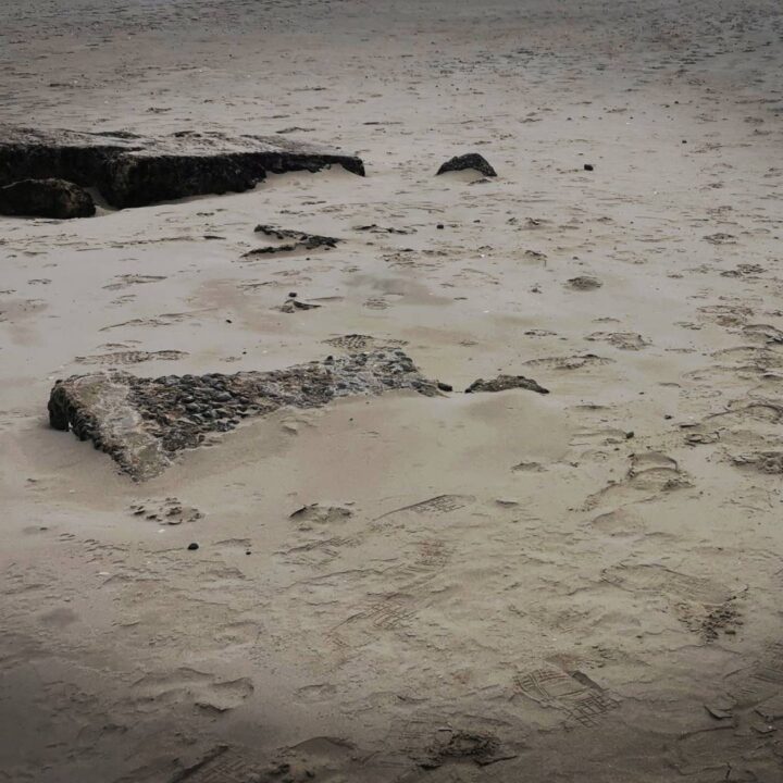 Remains of a half-buried concrete structure remain as evidence of Second World War pillbox on the beach at Murlough Bay, Co. Down.
