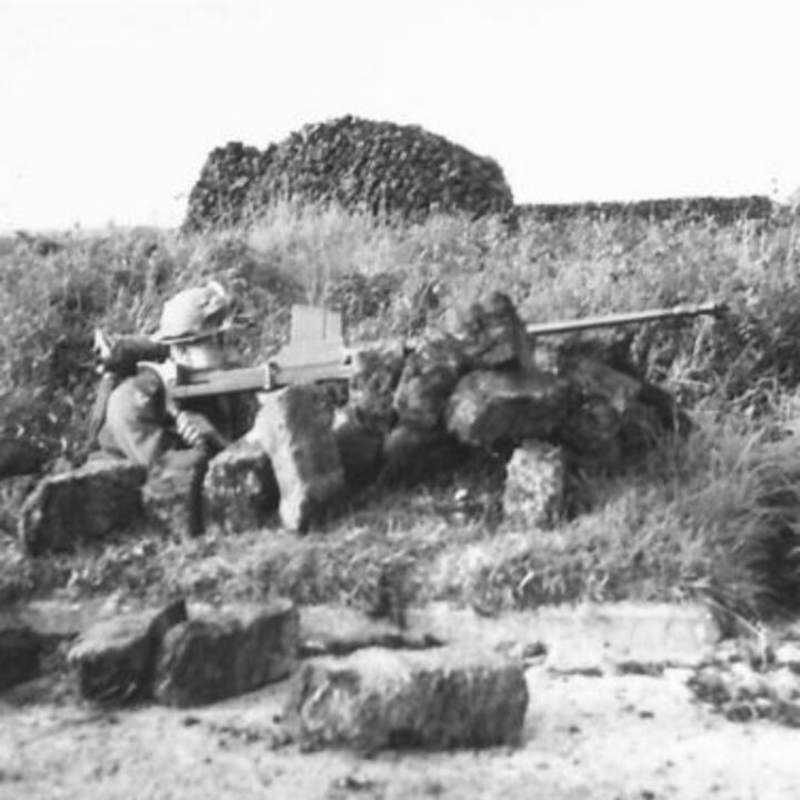 An Anti-Tank Rifleman of 2nd Battalion, Royal Inniskilling Fusiliers takes position among the cover of peat stacks covering the approach of 