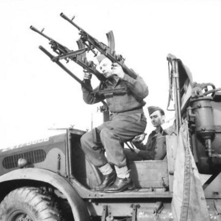 A soldier demonstrating a twin-mounting for a Bren Gun on a Portee Truck during a training exercise in Northern Ireland.
