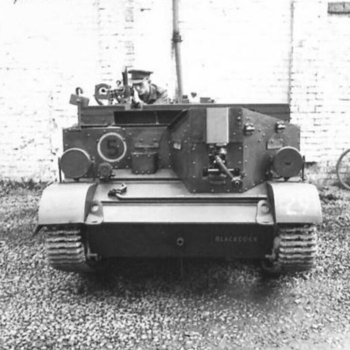 Photograph showing gun firing mountings on a Universal Carrier in Northern Ireland. A soldier demonstrates firing a Boys Anti-Tank Rifle and Bren Gun to the front.