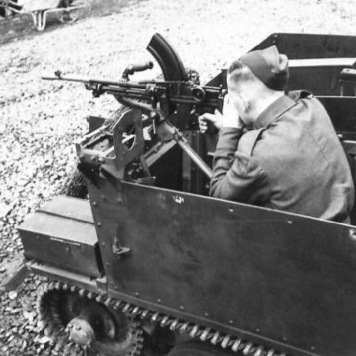 Photograph showing gun firing mountings on a Universal Carrier in Northern Ireland. A soldier demonstrates firing a Bren Gun to the rear.