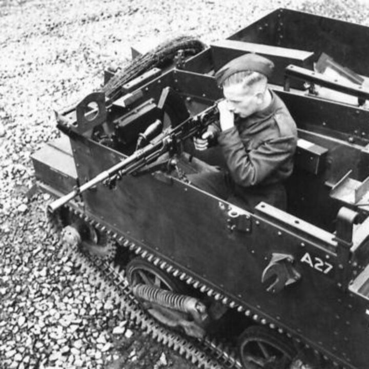 Photograph showing gun firing mountings on a Universal Carrier in Northern Ireland. A soldier demonstrates firing a Bren Gun to the right-hand side.