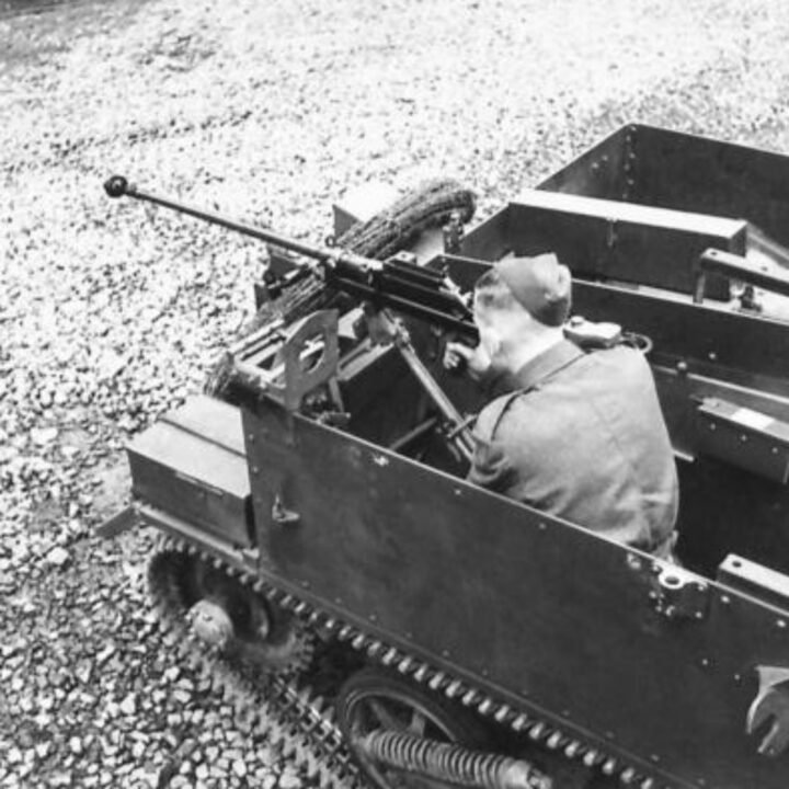 Photograph showing gun firing mountings on a Universal Carrier in Northern Ireland. A soldier demonstrates firing a Boys Anti-Tank Rifle to the rear.