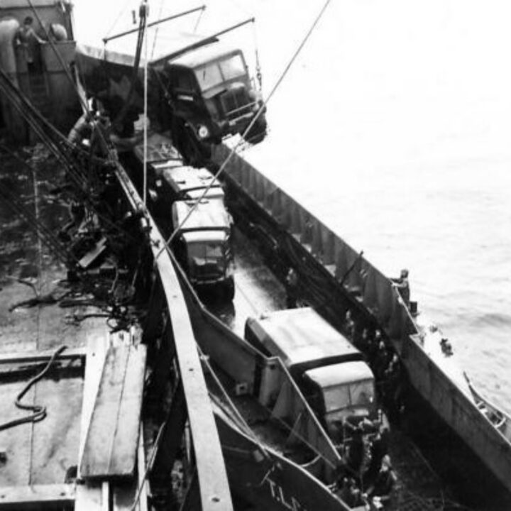 The British Army unload stores and equipment including army lorries from a stranded vessel onto a landing craft to ready the steamship for refloating. S.S. Bereby ran aground at Ardglass, Co. Down.