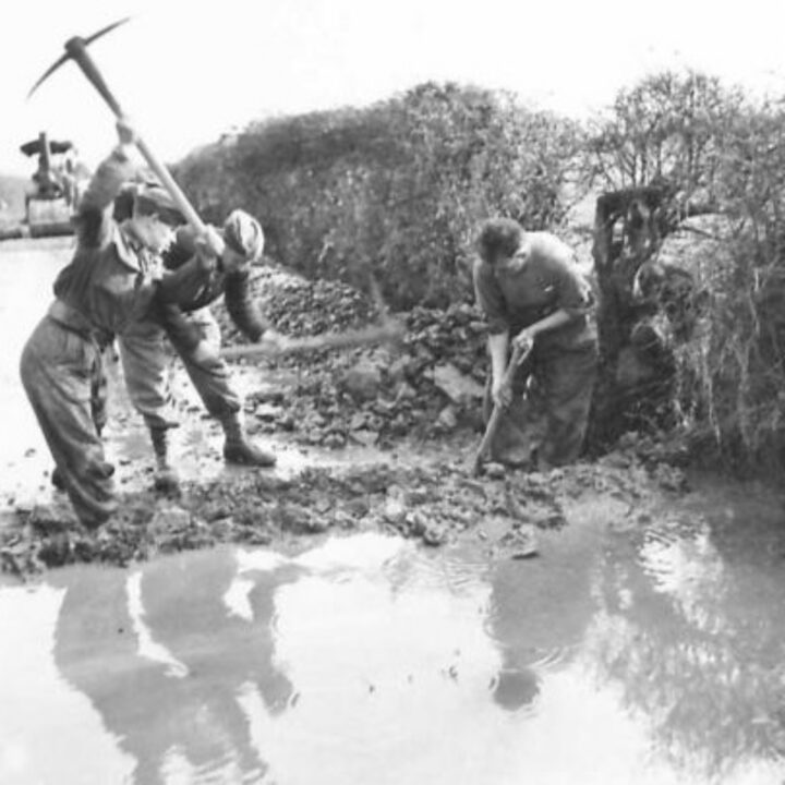 Members of The Pioneer Corps construct a drainage trench across a road in Northern Ireland.