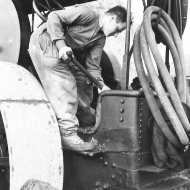 A member of The Pioneer Corps stoking the fire on a steam roller while carrying out road repair work in Northern Ireland.