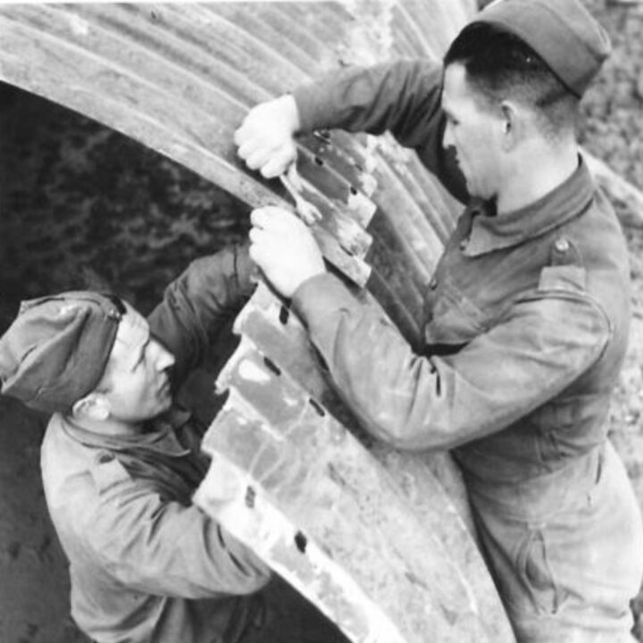 Members of The Pioneer Corps construct a Nissen hut at an airfield in Northern Ireland.