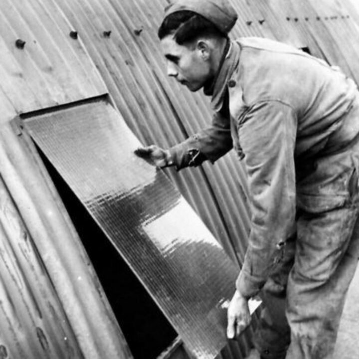 A member of The Pioneer Corps fitting a window in a hut in Northern Ireland.