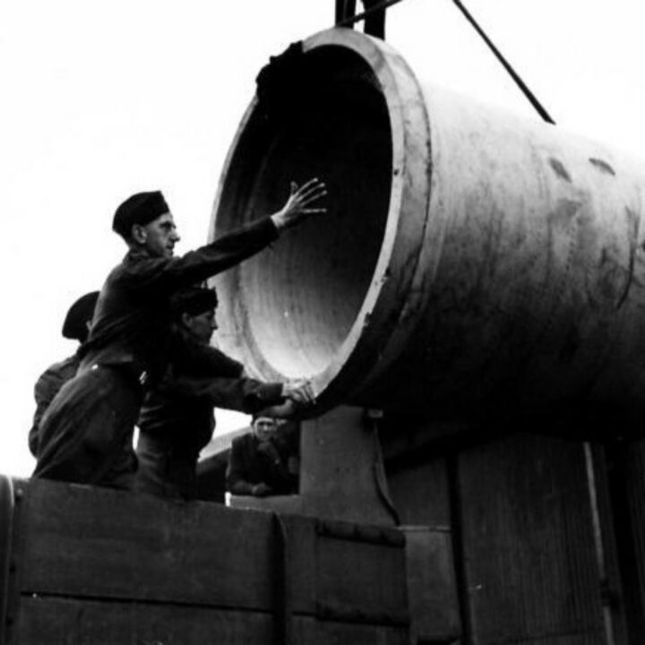 Members of The Pioneer Corps unloading reinforced concrete pipes at a quayside in Northern Ireland.