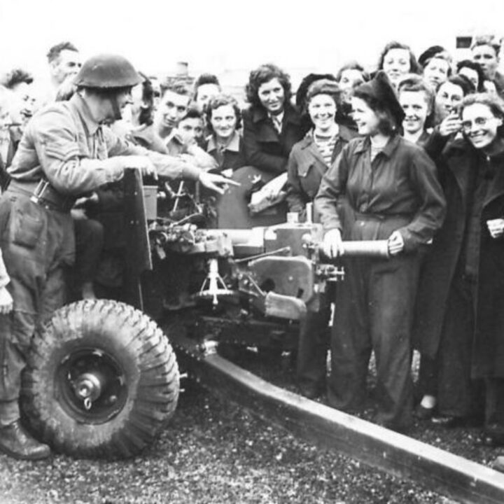 A Royal Artillery Sergeant from a gun demonstration team explains the process of loading a 6-pounder Anti-Tank Gun to munition workers from a factory in Northern Ireland.