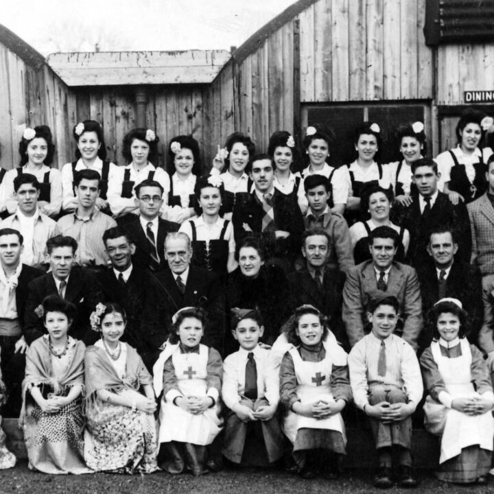 Evacuees from Gibraltar including members of the Martinez family and friends pose in costume outside the Nissen huts that served as dining rooms and community centres at Camp no. 2, Cargagh near Downpatrick, Co. Down.