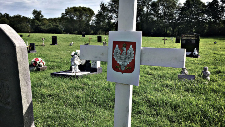 A plain white wooden cross marks the site of a number of graves belonging to Polish service personnel of the Second World War at Milltown Cemetery on the Falls Road in West Belfast.