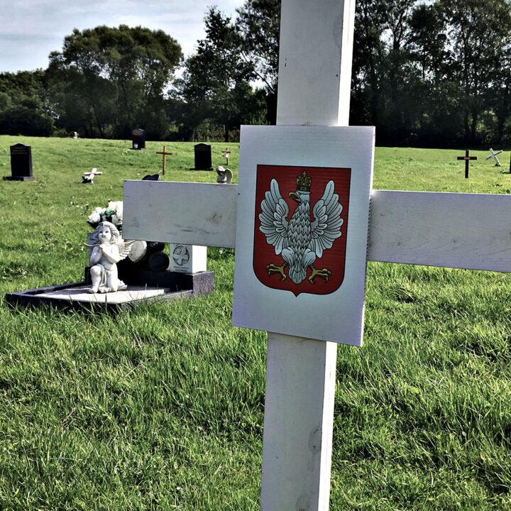 A plain white wooden cross marks the site of a number of graves belonging to Polish service personnel of the Second World War at Milltown Cemetery on the Falls Road in West Belfast.