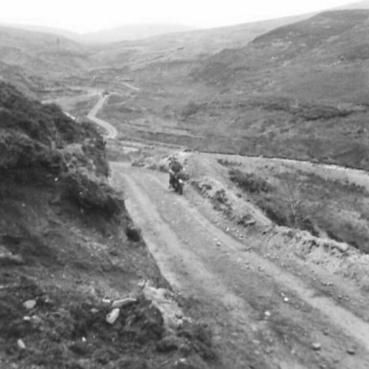Members of the 61st Divisional Engineers cutting a new road through the Sperrin Mountains at Templemoyle, south of Dungiven, Co. Londonderry. A soldier travels across a section of the new road by motorcycle.