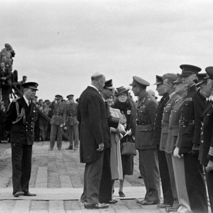 King George VI meets with the Duke of Abercorn (Governor of Northern Ireland) at Musgrave Channel, Belfast. Also present are a number of senior military officers including Major-General Russell P. Hartle (U.S. Army) and Air Vice Marshal J. Cole-Hamilton (Air Officer Commanding for Northern Ireland).