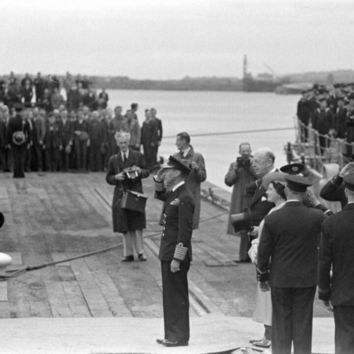 King George VI saltues Rear Admiral Richard Matthew King D.S.O. (Flag Officer in Charge Belfast. H.M.S. Caroline). Immediately behind the King are Queen Elizabeth and the Duke of Abercorn (Governor of Northern Ireland).