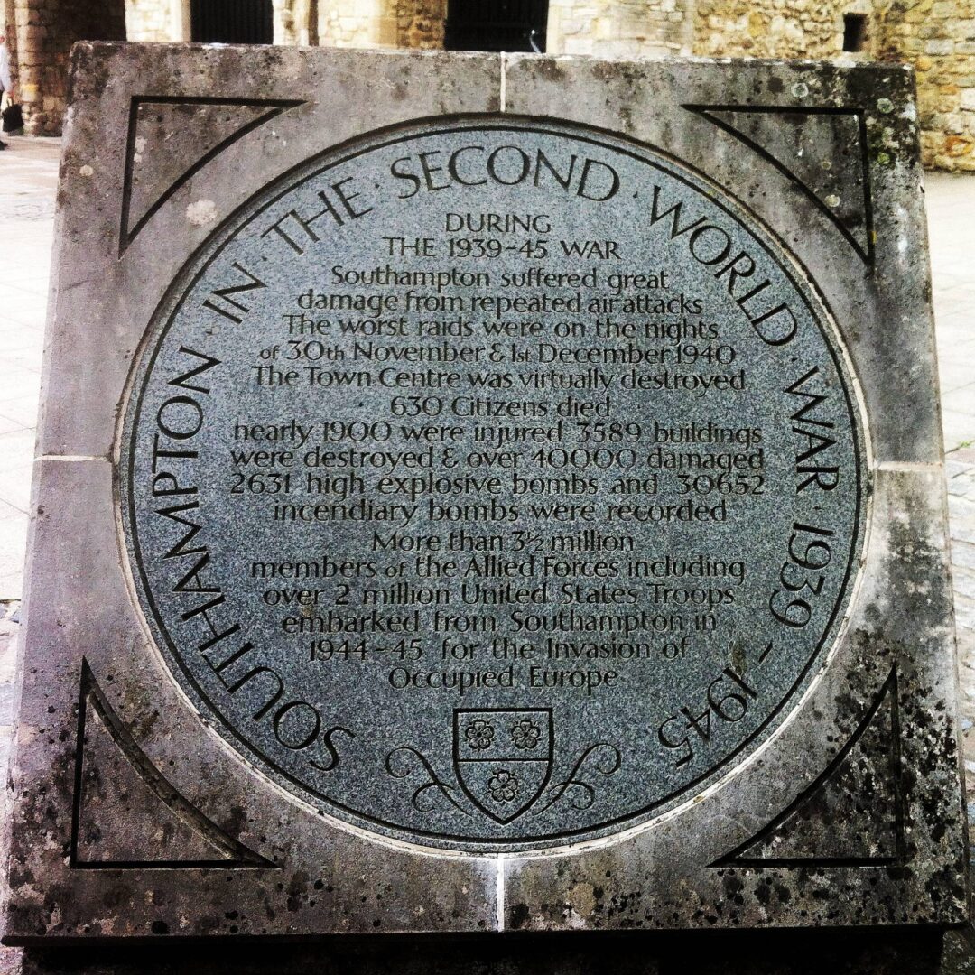 A memorial stone commemorating the role played by the town in the Second World War stands next to the old gates at High Street, Southampton, Hampshire, England in ruins.
