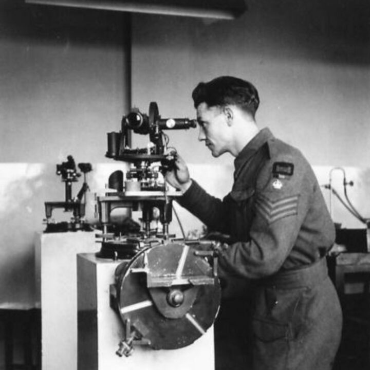 Staff Sergeant Tocher of Aberdeen, Scotland inspecting an American theodolite in need of repair at a Royal Electrical and Mechanical Engineers base workshop at Kinnegar Barracks, Holywood, Co. Down.