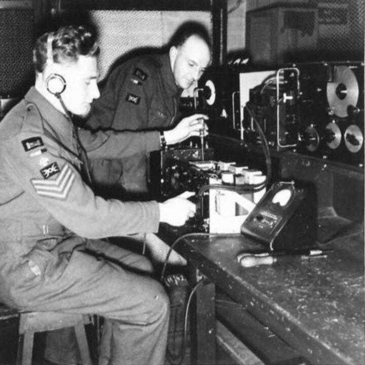 Armourer Staff Sergeant Mawdsley of Bacup, Lancashire, England and Craftsman Gillard of Hull, Yorkshire, England at work on delicate wireless radio equipment at a Royal Electrical and Mechanical Engineers base workshop at Kinnegar Barracks, Holywood, Co. Down.