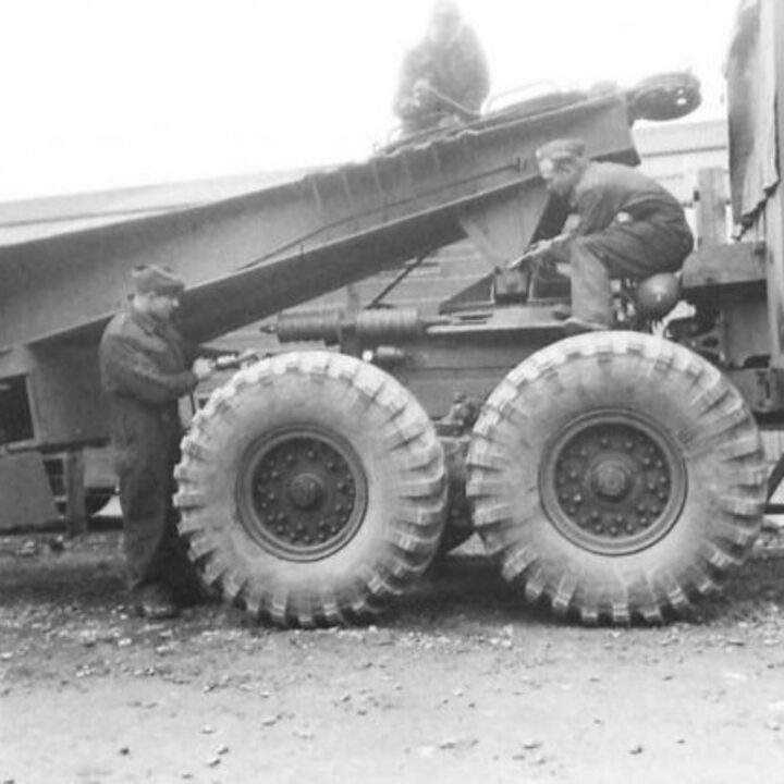 Driver Corporal Osborne of Hornsey, London, England, Lance Corporal Bolton of Wigan, Lancashire, England, and Craftsman Bradley of Woolwich, London, England at work on a tank transporter at a Royal Electrical and Mechanical Engineers base workshop at Kinnegar Barracks, Holywood, Co. Down.