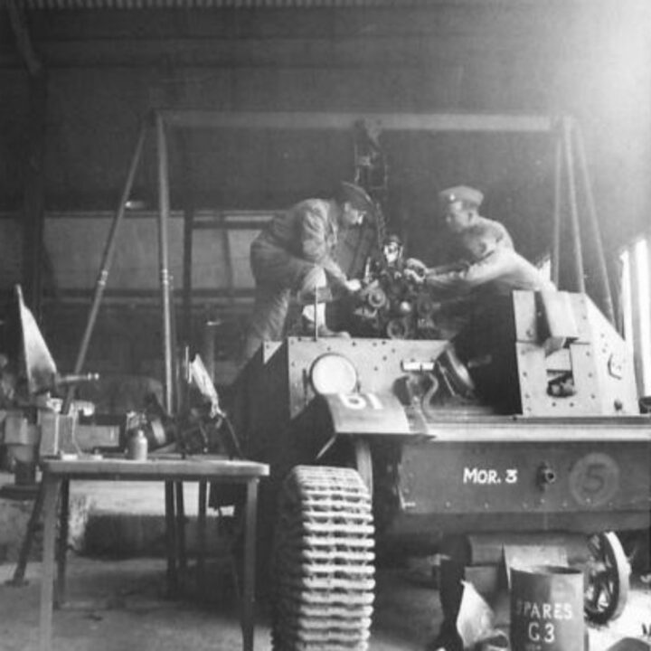 Craftsman G. Erselius of Holloway, London, England, Lance Corporal H. Roberts of Northwich, Cheshire, England, and Sergeant W. Wallis of New Malden, Surrey fitting an engine to a Universal Carrier at 3 Non Divisional Engineers, Royal Electrical and Mechanical Engineers base workshop at Gilford, Co. Down.