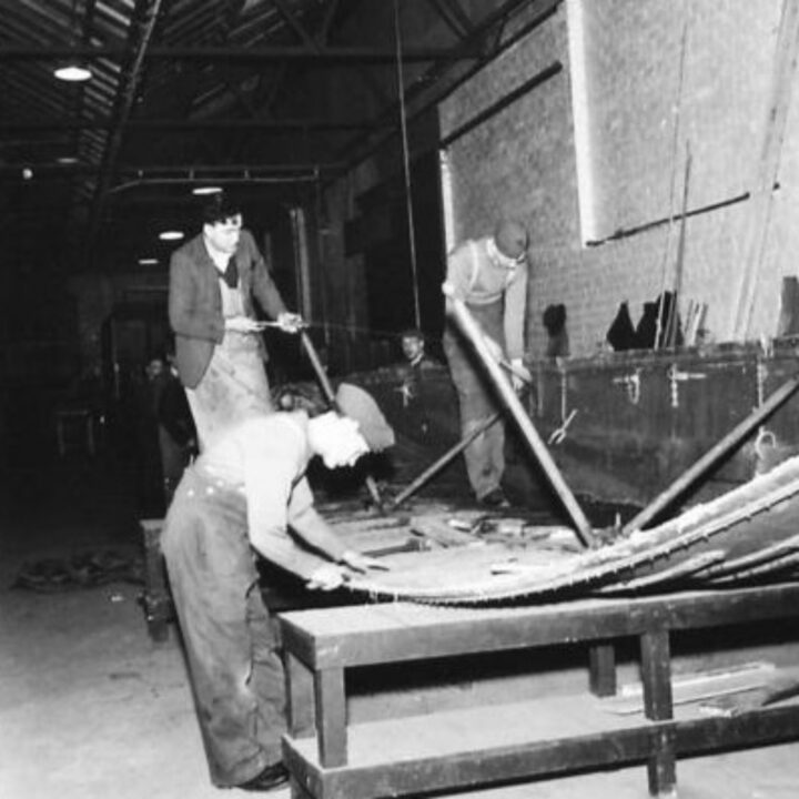 Craftsman J. Blair of Derry~Londonderry and Craftsman H. Rennie of Strichen, Aberdeenshire, Scotland working repairing assault boats at a Royal Electrical and Mechanical Engineers base workshop at Kinnegar Barracks, Holywood, Co. Down.