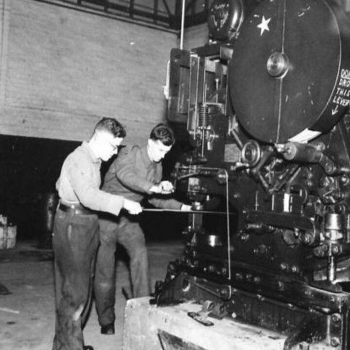 Craftsman J. Hanley of Bolton, Lancashire, England and Lance Corporal N. Snowdon of Newcastle-upon-Tyne, England punching sheet metal at a Royal Electrical and Mechanical Engineers base workshop at Kinnegar Barracks, Holywood, Co. Down.