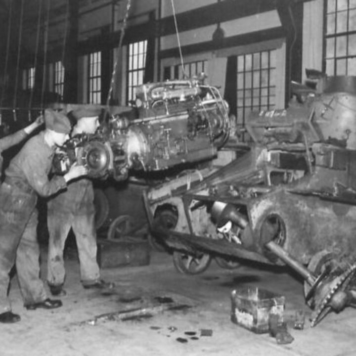 Craftsman J. Fisher of Manchester, England and Sergeant Darragh of Belfast fitting an engine in to a Valentine Tank at a Royal Electrical and Mechanical Engineers base workshop at Kinnegar Barracks, Holywood, Co. Down.