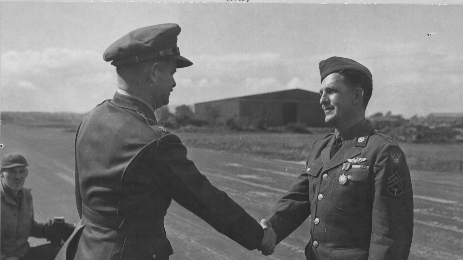 Lieutenant Colonel R.W. Crisp presents the Air Medal to Staff Sergeant George B. Boyte, a B-24 gunner from Lewiston, Idaho, U.S.A. during a ceremony at U.S.A.A.F. Station 236, Toome Airfield, Co. Antrim on 2nd September 1943.