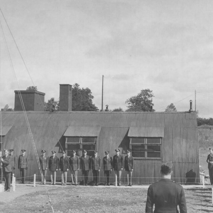 Personnel of the Royal Air Force and United States Army Air Force salute the raising of the Stars and Stripes as R.A.F. Toome becomed U.S.A.A.F. Station 236 at Toome Airfield, Co. Antrim on 26th July 1943.