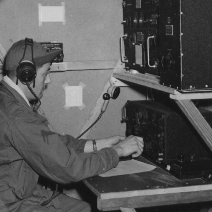 Radio Operator Corporal Paul Carrion operating radio equipment in the Harwell Box, a device used in procedure training to simulate the radio compartment of a bomber, at U.S.A.A.F. Station 236, Toome Airfield, Co. Antrim on 21st September 1943.