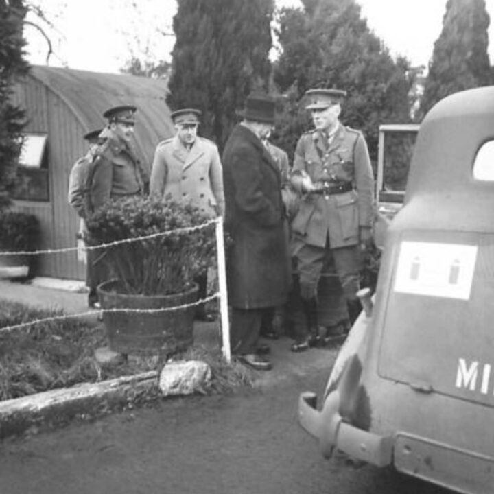 The Right Honourable Sir James Grigg K.C.B., K.C.S.I, P.C. (Secretary of State for War) talks with Lieutenant-Colonel J.D. Gage-Brown at a British Army camp in Northern Ireland. Lieutenant-General Sir Harold Edmund Franklyn in the background wears British Warm.