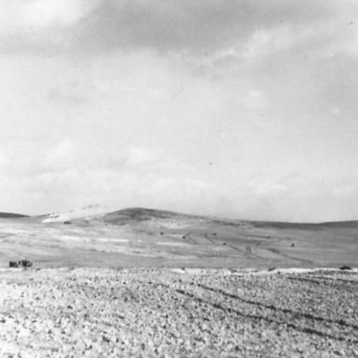 Crusader tanks of 6th Armoured Division and supporting troops advance the hill whil a smoke screen on the opposite side conceals the withdrawal of 6th Battalion, Royal Inniskilling Fusiliers following the attack at Two Tree Hill, Bou Arada, Tunisia.