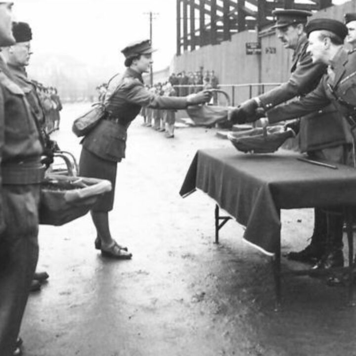 A Company Commander of the Auxiliary Territorial Service receives the presented shamrock. The event is the presentation of the St. Patrick's Day Shamrock by Brigadier P.H. Hansen V.C. to members of 31st Battalion Royal Ulster Rifles, U.S. Army Officers of Irish descent, and members of the Auxiliary Territorial Service at Dunmore Park, Belfast.