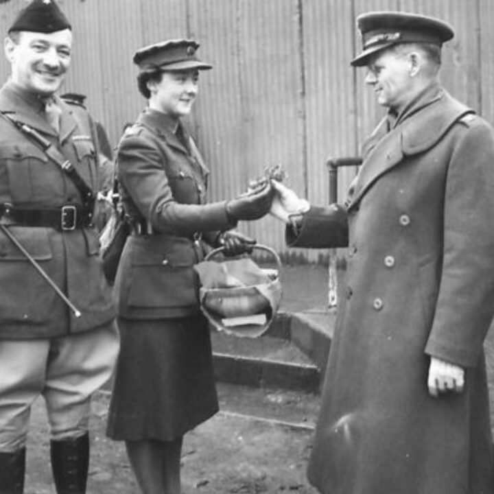An Officer of the Auxiliary Territorial Service presents the shamrock to Colonel F.T. Gillespie of the United States Army. The event is the presentation of the St. Patrick's Day Shamrock by Brigadier P.H. Hansen V.C. to members of 31st Battalion Royal Ulster Rifles, U.S. Army Officers of Irish descent, and members of the Auxiliary Territorial Service at Dunmore Park, Belfast.