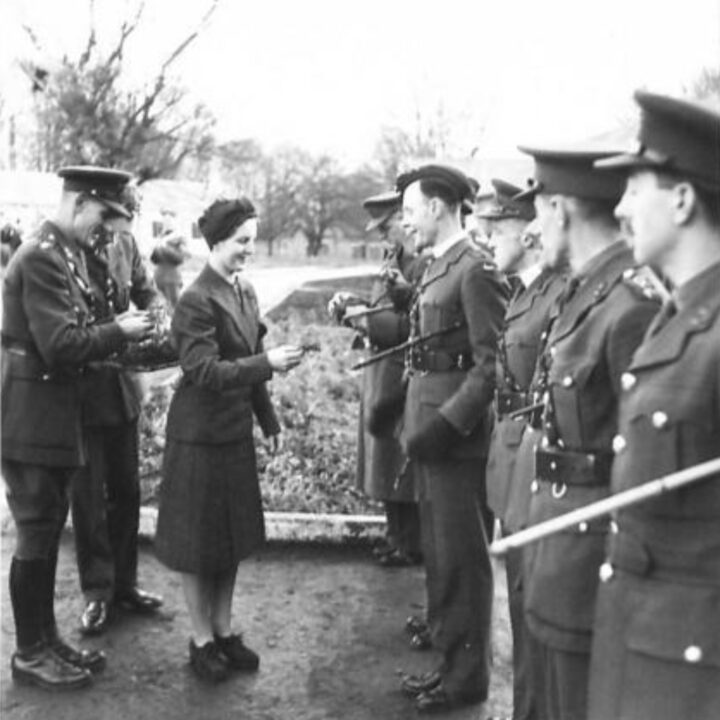 Mrs. Heard presents the shamrock to the Padre at 25th Initial Training Centre in Omagh, Co. Tyrone. The event is the presentation of the St. Patrick's Day Shamrock by Mrs. Heard, wife of Lieutenant Colonel R.A. Heard M.C., Commandant of 25th Infantry Training Centre to soldiers in Omagh, Co. Tyrone.