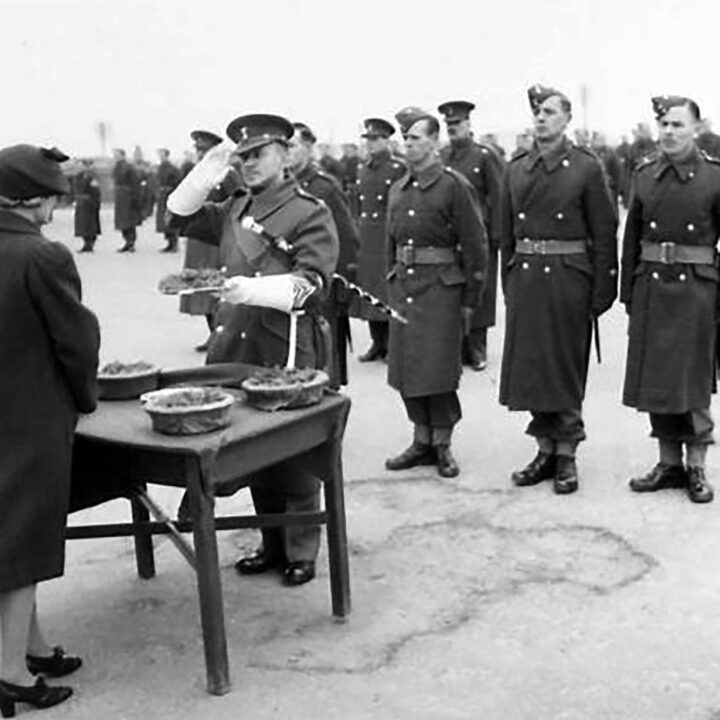 Mrs. Allen, the wife of the Commanding Officer gives springs of shamrock to Drum Major Pogue to distribute among his band. The event is the presentation of the St. Patrick's Day Shamrock to members of a Battalion of the Royal Irish Fusiliers at Ballykinler, Co. Down.