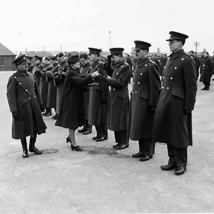 Mrs. Allen, the wife of the Commanding Officer, accompanied by her husband, gives a sprig of shamrock to Officers. The event is the presentation of the St. Patrick's Day Shamrock to members of a Battalion of the Royal Irish Fusiliers at Ballykinler, Co. Down.