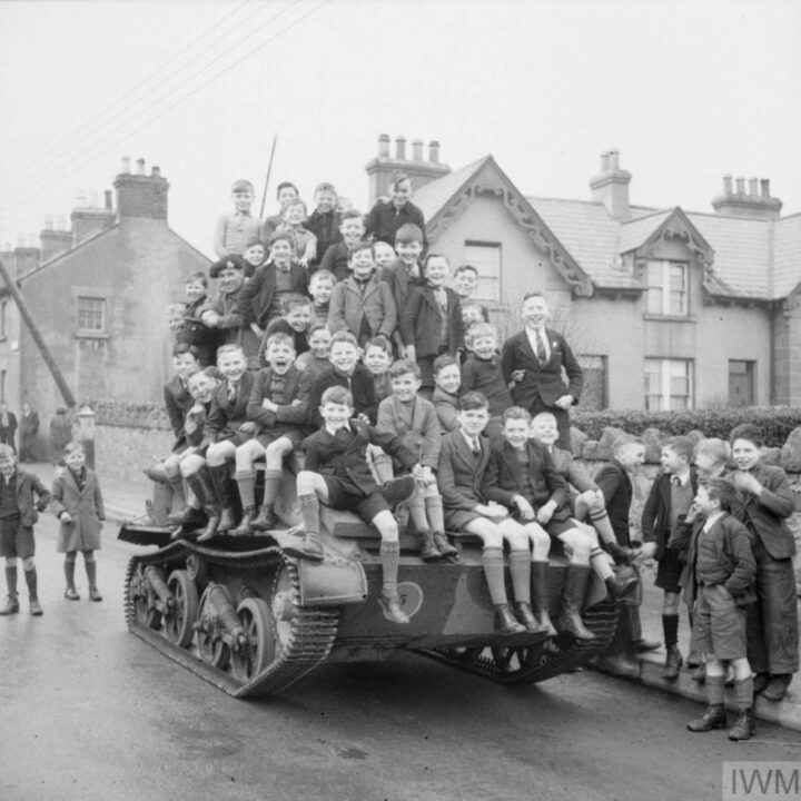 Local children posing for a photograph on a Mark VI Light Tank before a training exercise. A and B Squadron, 2nd Battalion, Fife and Forfar Yeomanry, Royal Armoured Corps attached to 53rd (Welsh) Infantry Division training at Derrymore House, Bessbrook, Co. Armagh.