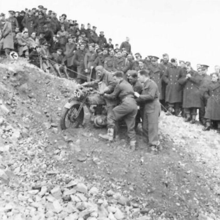 A competitor receives help climbing a steep incline. British Army motorcycle trials held at the old lead mines at Whitespots near Conlig, Co. Down.