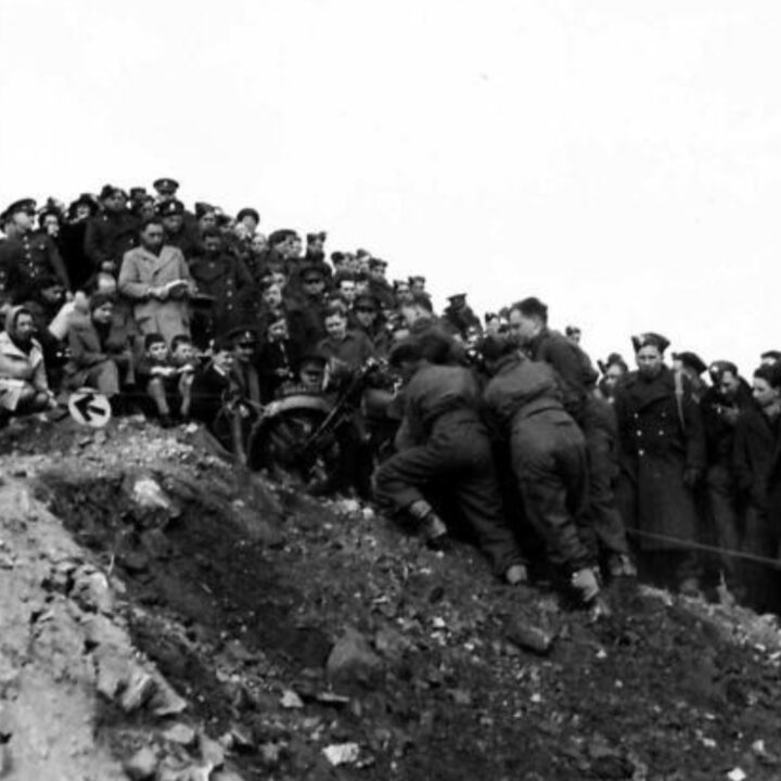 A competitor receives help climbing a steep incline. British Army motorcycle trials held at the old lead mines at Whitespots near Conlig, Co. Down.