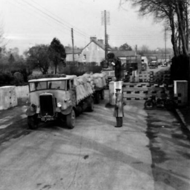A traffic control policeman of 2/3 Traffic Control Company, Corps of Military Police using a new type of signal to help direct traffic flow in Ballynure, Co. Antrim.