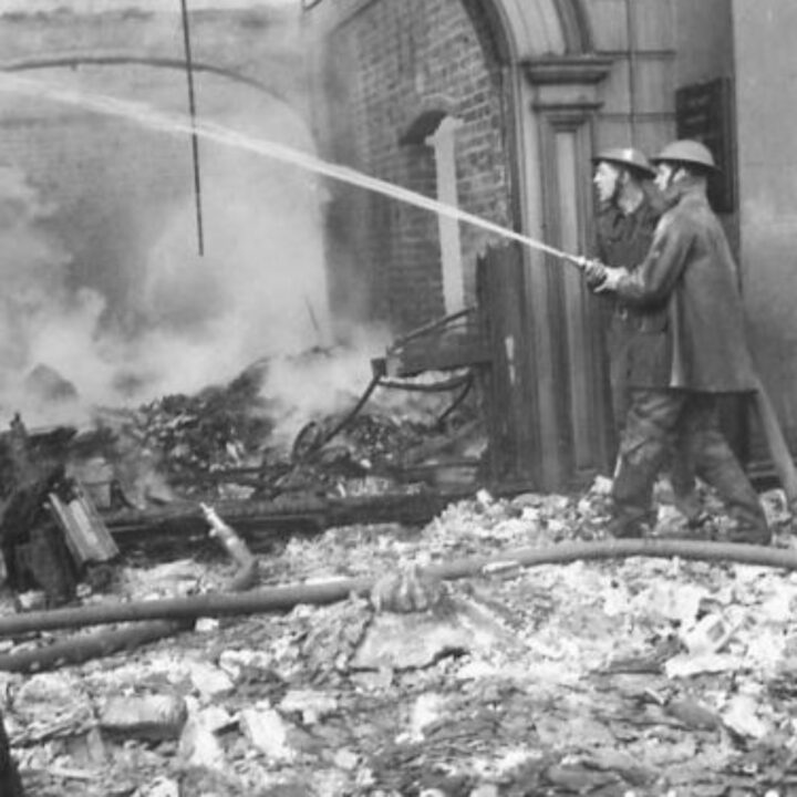 Firefighters dousing rubble and debris in the aftermath of the Easter Raid of the Belfast Blitz.