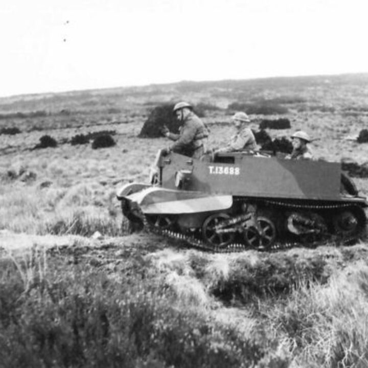 Soldiers of 1/5th Battalion, The Welsh Regiment travel over open moorland past stacks of peat in a Universal Carrier near Newry, Co. Down.