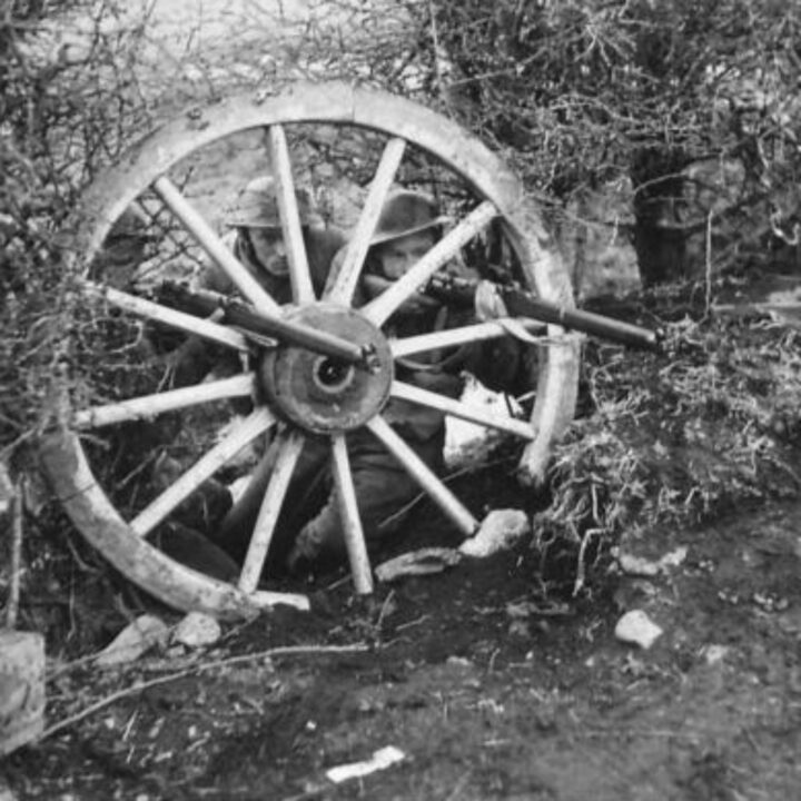Soldiers of 1/5th Battalion, The Welsh Regiment concealed behind an old cart wheel during a training exercise near Newry, Co. Down.