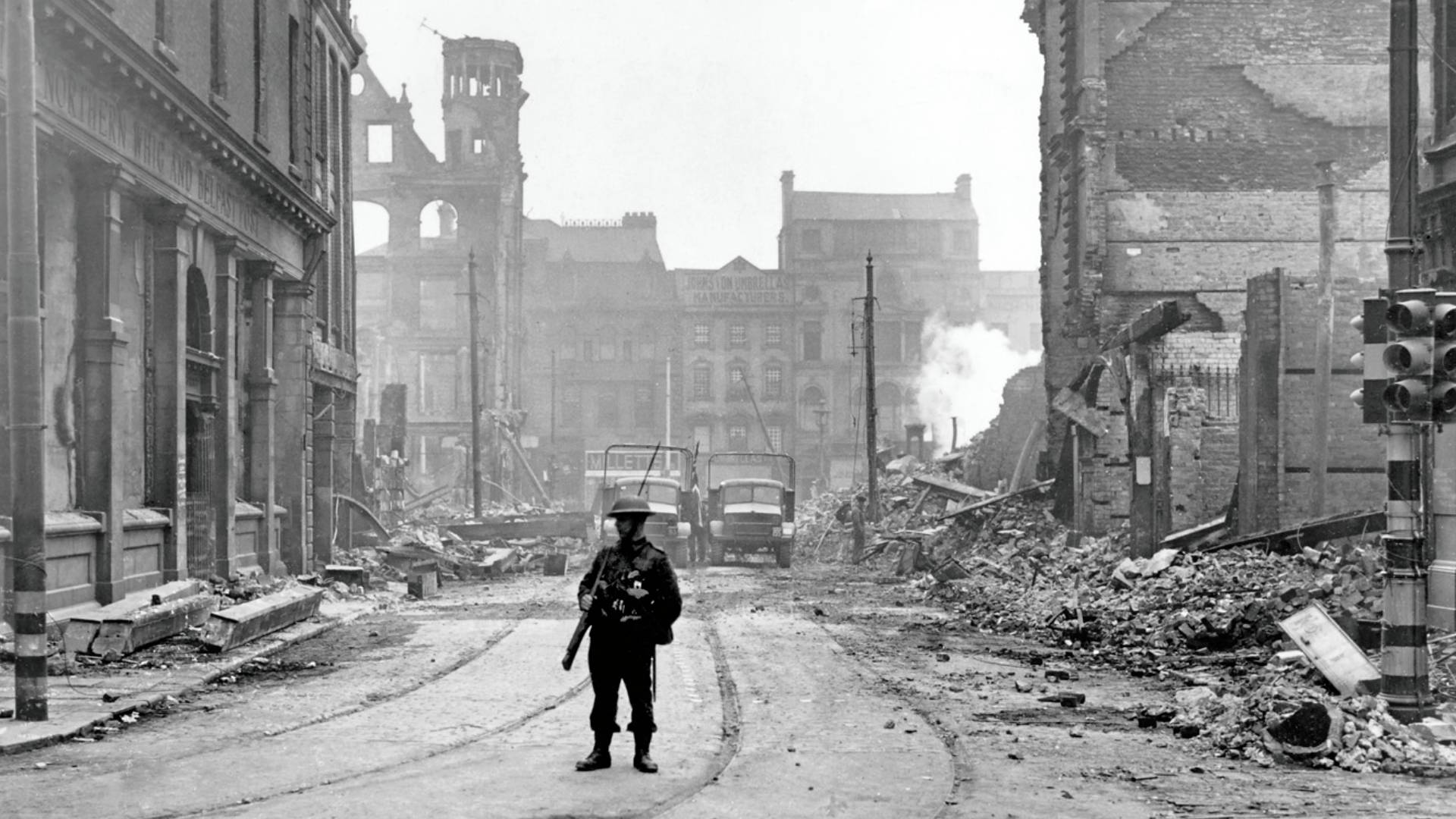A soldier looks towards the damaged offices of the Northern Whig newspaper on Bridge Street, Belfast in the aftermath of the Fire Raid of the Belfast Blitz.