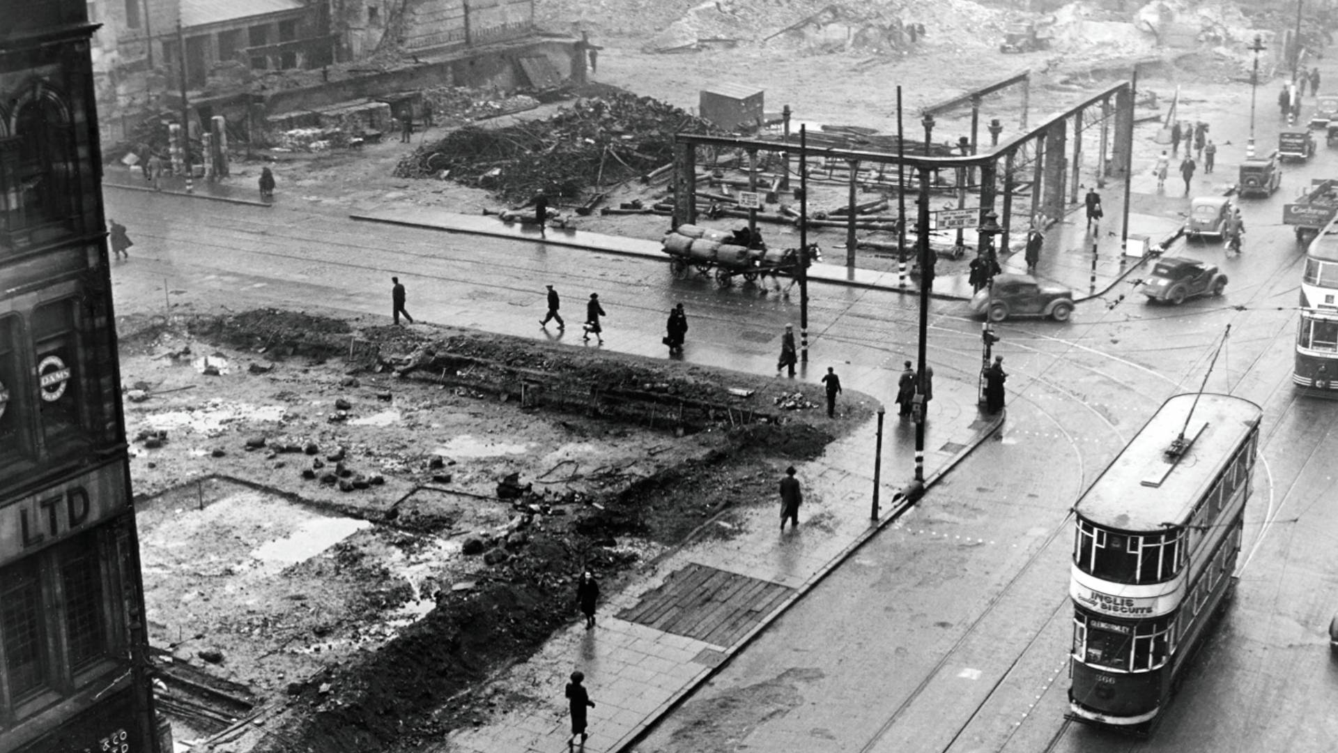 Rubble strewn plots, frames of buildings, and large cleared areas remain at the junction of High Street and Bridge Street months after the Luftwaffe attacks on Belfast city centre.